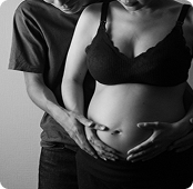 夫婦がお腹に手を重ねているマタニティフォト
